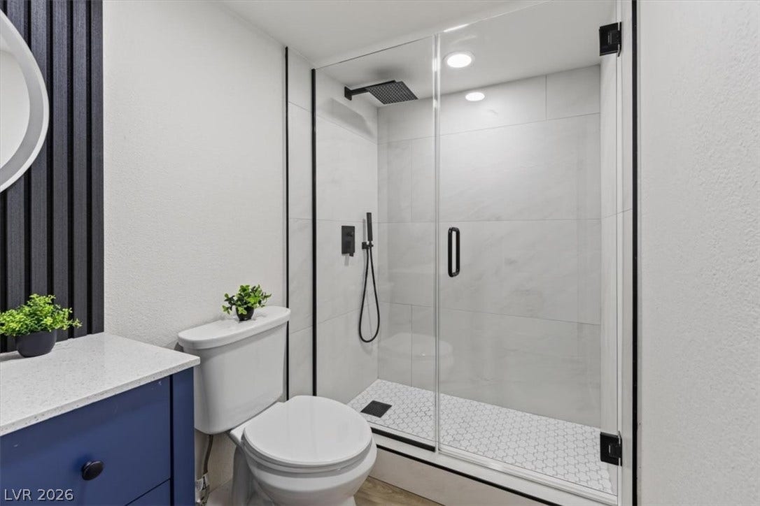 2606 S Durango Drive, #128, Las Vegas, NV 89117 Clean modern finishes anchor this bath with a glass-enclosed shower and tiled surrounds.