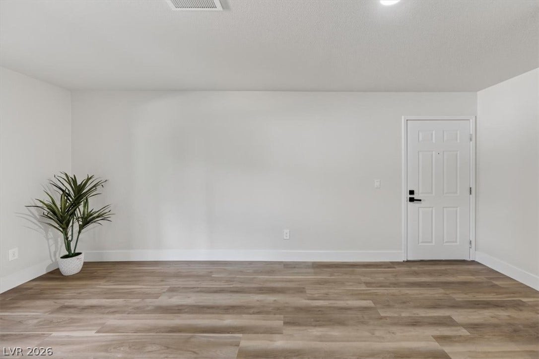 2606 S Durango Drive, #128, Las Vegas, NV 89117 Smooth wood-style flooring anchors this versatile space featuring clean lines and a classic paneled door.