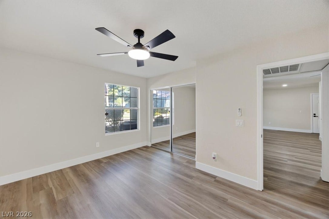 2606 S Durango Drive, #128, Las Vegas, NV 89117 Rich wood-inspired flooring pairs with a classic mirrored closet inside this versatile bedroom space.