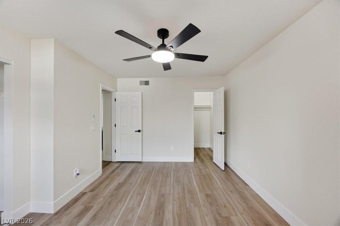2606 S Durango Drive, #128, Las Vegas, NV 89117 A spacious bedroom features modern wood-style flooring and freshly finished neutral walls.