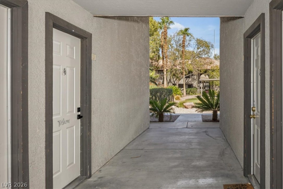 2606 S Durango Drive, #128, Las Vegas, NV 89117 A covered exterior entry features concrete flooring and leads directly to a landscaped courtyard path.