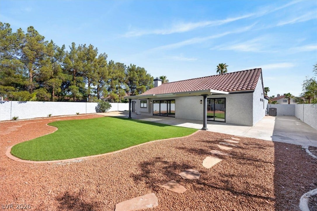 2606 S Durango Drive, #128, Las Vegas, NV 89117 A spacious tiled-roof patio opens onto a pristine, low-maintenance backyard with manicured turf.