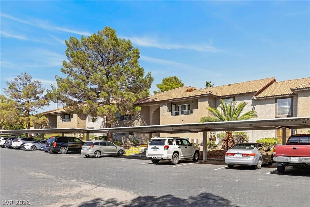 2606 S Durango Drive, #128, Las Vegas, NV 89117 Stucco exteriors and Spanish tile roofs define this residential complex featuring covered carport parking spaces.
