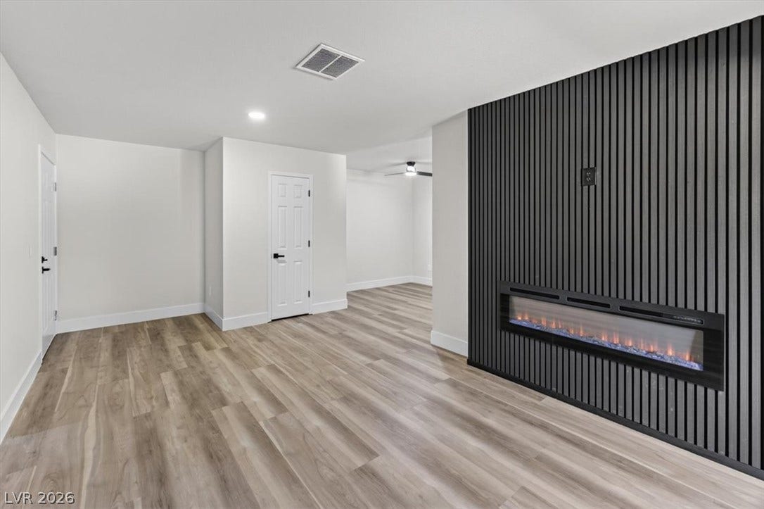 2606 S Durango Drive, #128, Las Vegas, NV 89117 A modern electric fireplace set in a slatted wood feature wall highlights this versatile living space.