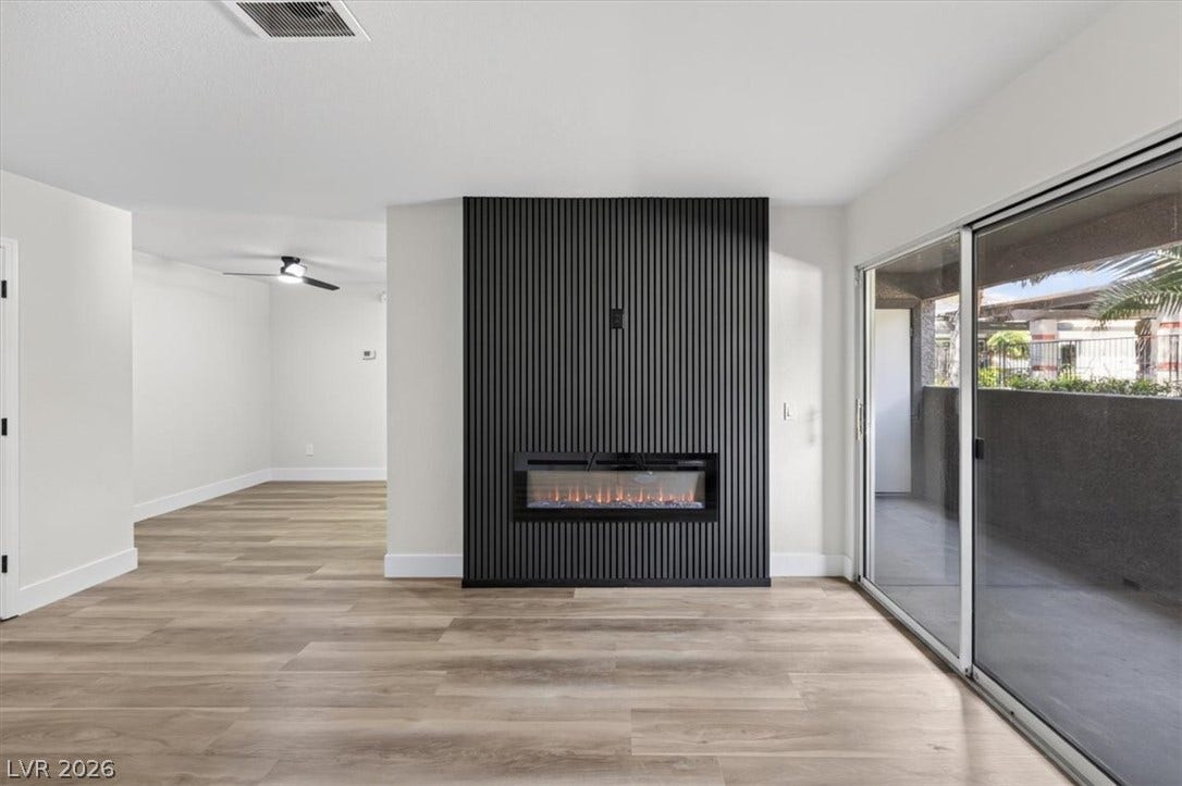 2606 S Durango Drive, #128, Las Vegas, NV 89117 Clean lines and wood flooring frame a striking modern fireplace in this open living space.