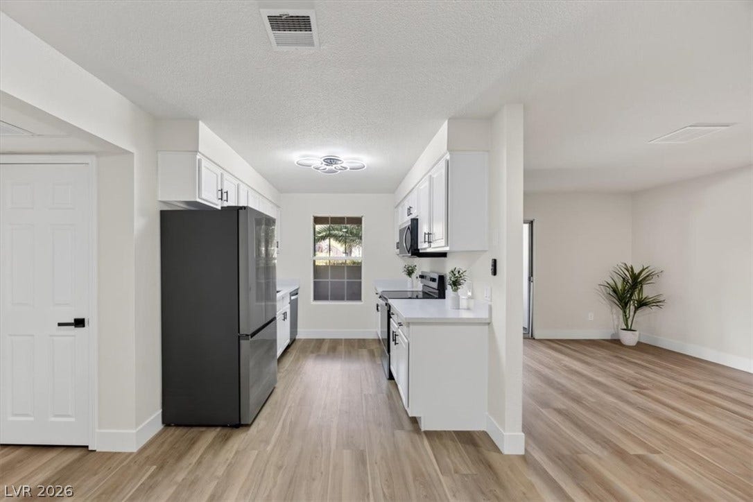 2606 S Durango Drive, #128, Las Vegas, NV 89117 Smooth wood-look flooring connects this galley kitchen to the adjacent open living space.