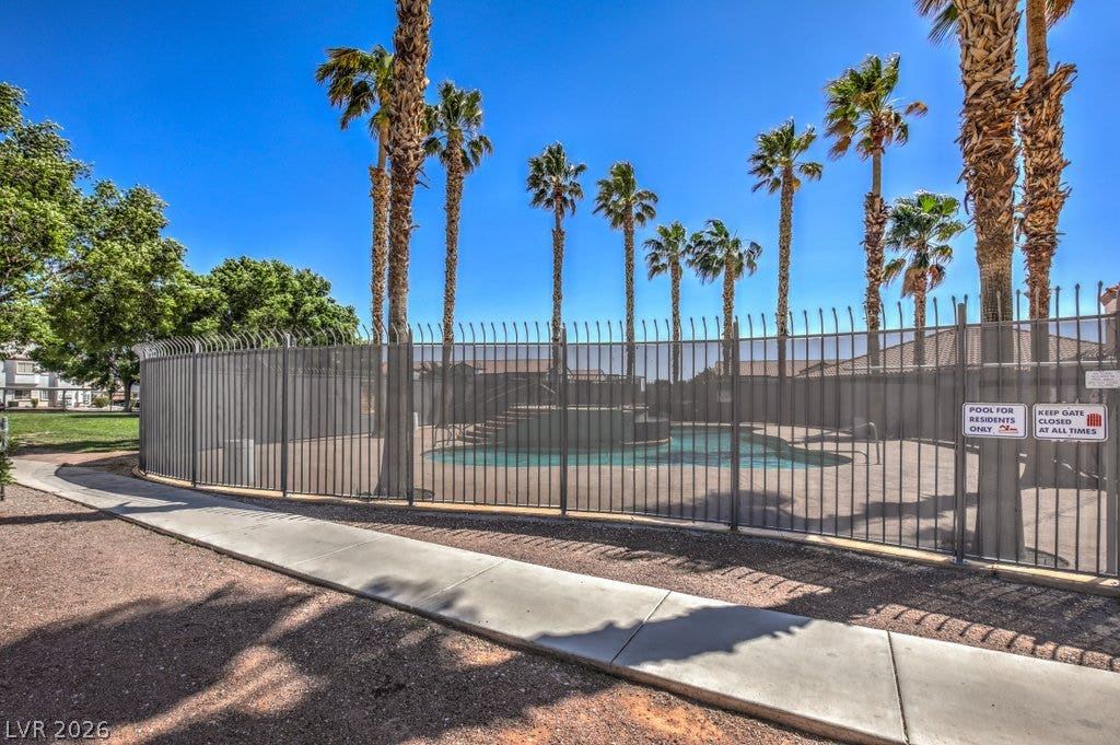 3318 N Decatur Boulevard, #2142, Las Vegas, NV 89130 Secure fencing surrounds a pristine community swimming pool lined with soaring palm trees.