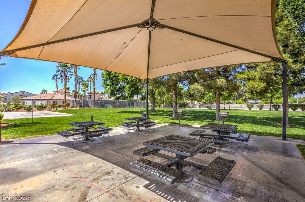 3318 N Decatur Boulevard, #2142, Las Vegas, NV 89130 Shaded picnic tables anchor a concrete patio overlooking a manicured lawn.