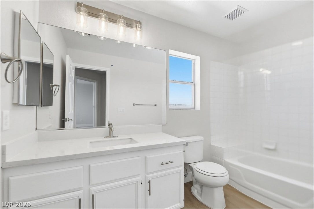 1906 Cardinal Point Street, Henderson, NV 89012 Natural light from a classic window brightens a modern washroom with plank flooring.