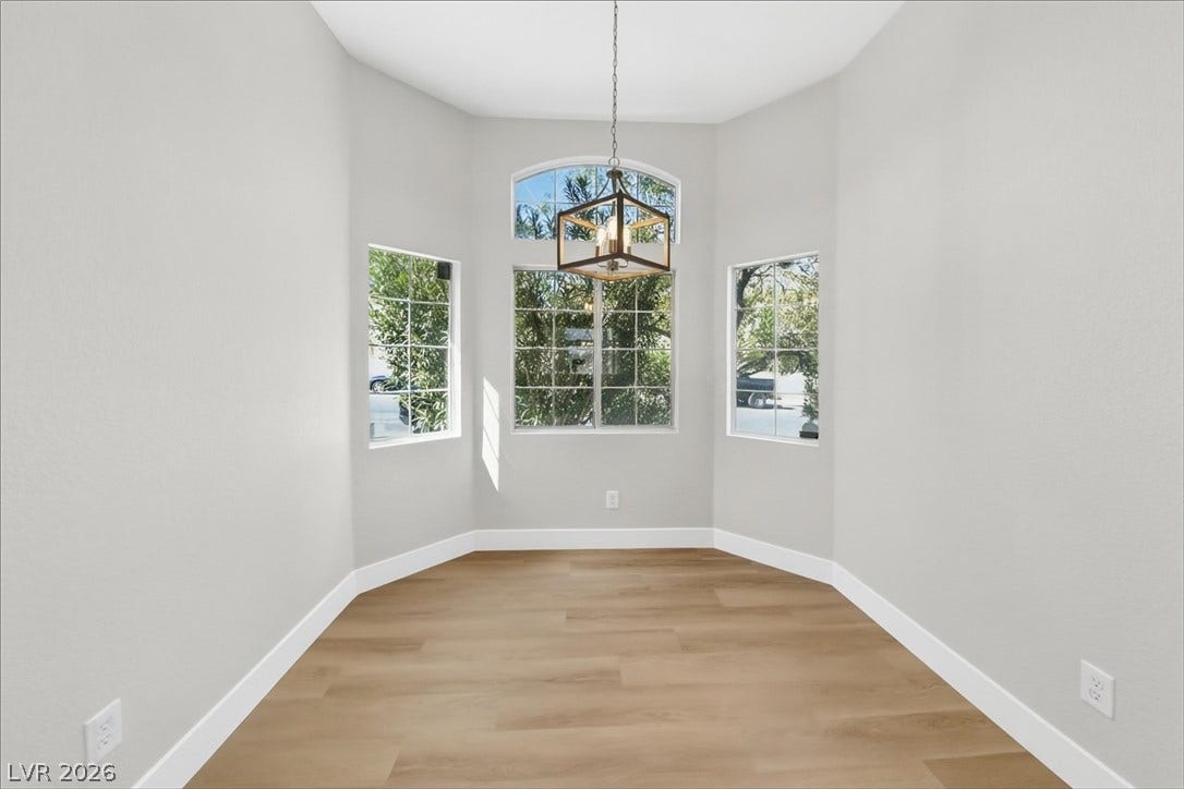 1906 Cardinal Point Street, Henderson, NV 89012 Arched windows frame garden views, illuminating the polished wood floors in this inviting space.