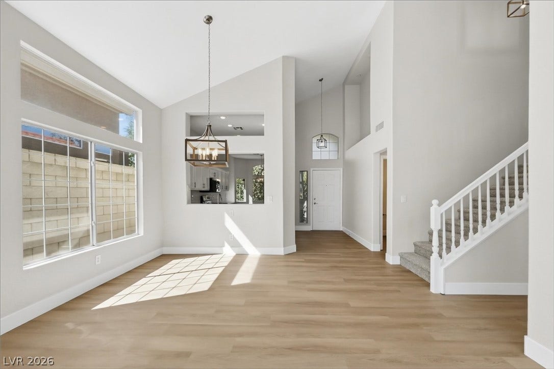 1906 Cardinal Point Street, Henderson, NV 89012 High vaulted ceilings and rich wood-inspired floors anchor this sunlit open living space.