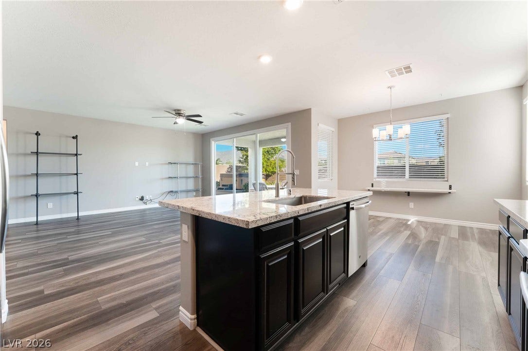 1430 Dire Wolf Avenue, North Las Vegas, NV 89084 An open floorplan seamlessly connects the stone-countertop kitchen with a bright dining space.