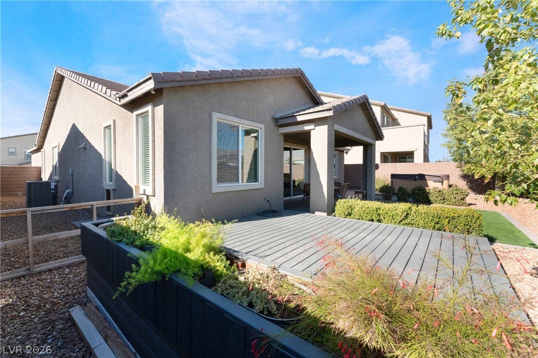 1430 Dire Wolf Avenue, North Las Vegas, NV 89084 An inviting wooden deck transitions seamlessly to a covered patio space under clear blue skies.