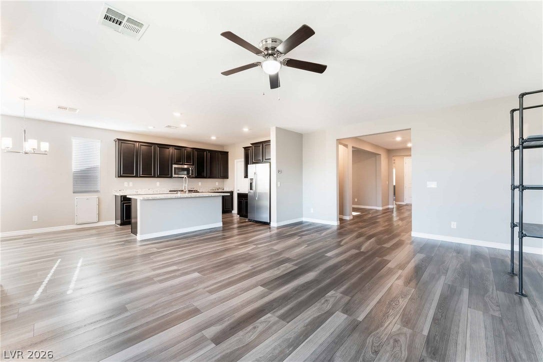 1430 Dire Wolf Avenue, North Las Vegas, NV 89084 Gleaming wood-inspired floors anchor an airy open floorplan connecting the living space and kitchen.