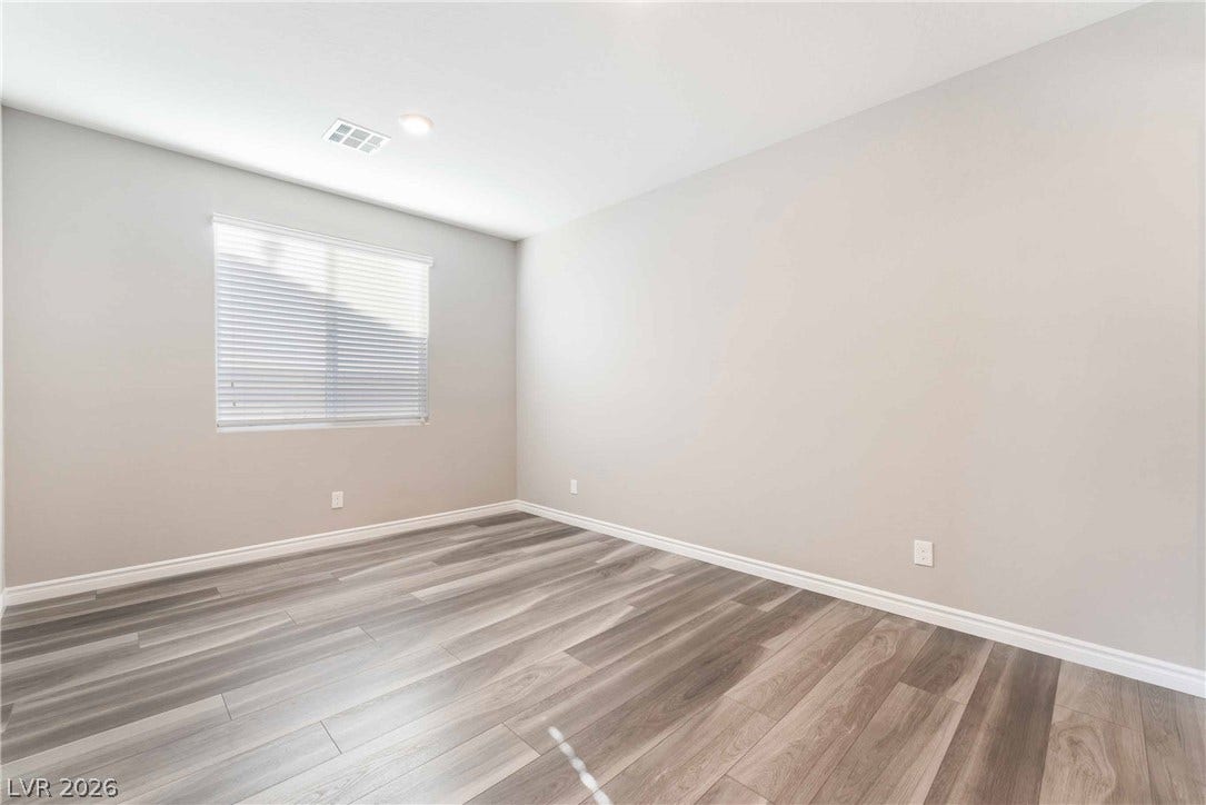 1430 Dire Wolf Avenue, North Las Vegas, NV 89084 Gleaming wood-look floors and clean minimalist lines anchor this versatile, airy interior space.