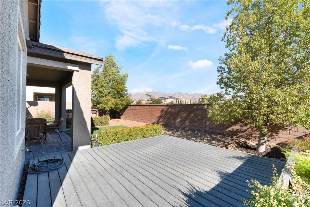 1430 Dire Wolf Avenue, North Las Vegas, NV 89084 An inviting wooden deck extends into the private fenced yard under clear blue skies.