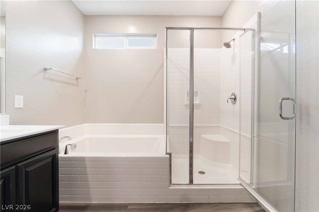 1430 Dire Wolf Avenue, North Las Vegas, NV 89084 Clean modern finishes define this bathroom complete with a glass-enclosed shower and adjacent soaking tub.