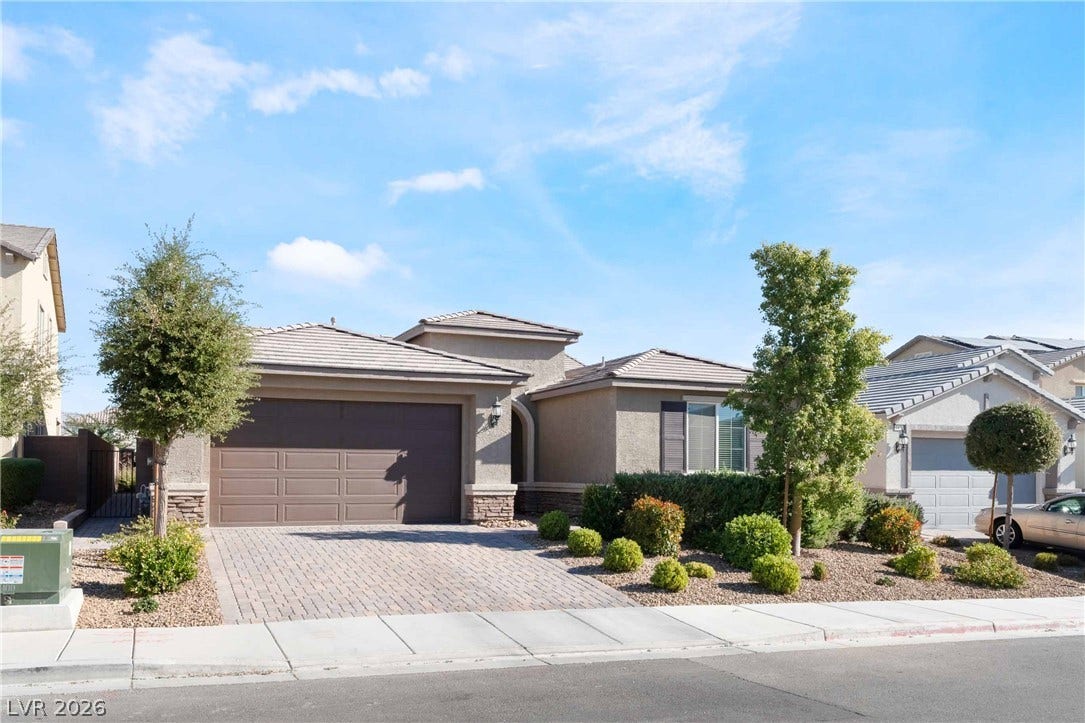 1430 Dire Wolf Avenue, North Las Vegas, NV 89084 Manicured desert plantings and a paved driveway complement this classic stucco exterior.