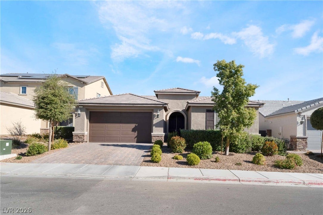 1430 Dire Wolf Avenue, North Las Vegas, NV 89084 A classic stucco exterior with stone accents creates appealing curb appeal along a quiet street.