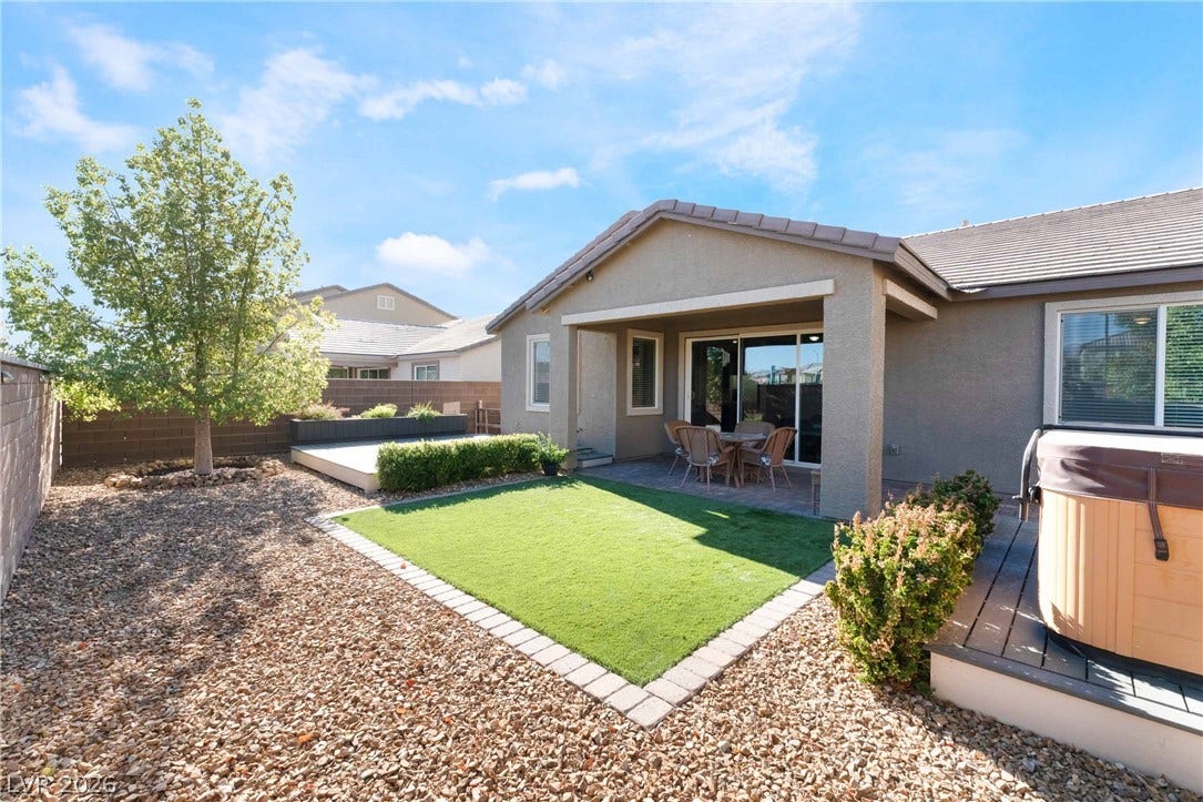1430 Dire Wolf Avenue, North Las Vegas, NV 89084 An inviting covered patio overlooks a manicured lawn and low-maintenance gravel landscaping.