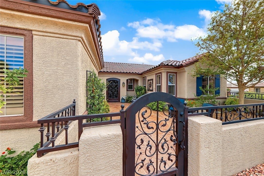 1646 Sebring Hills Drive, Henderson, NV 89052 An inviting gated courtyard features textured stucco walls and classic Spanish tile roofing.