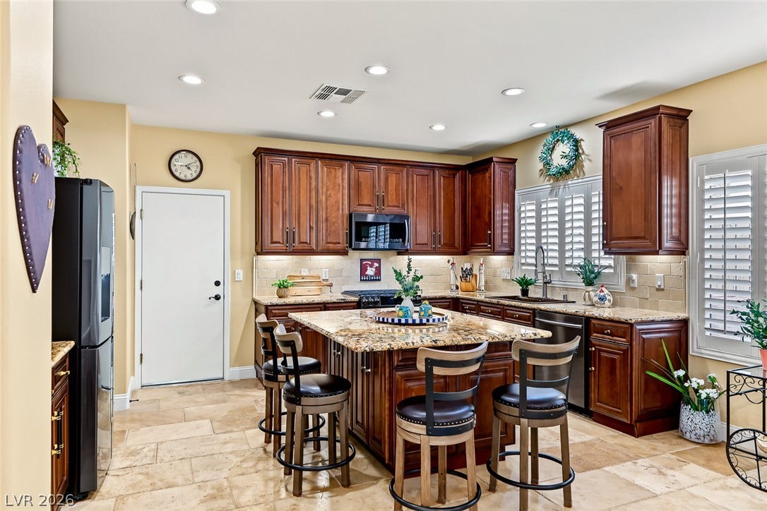 1646 Sebring Hills Drive, Henderson, NV 89052 Rich wood cabinetry and a central stone island define this inviting space.