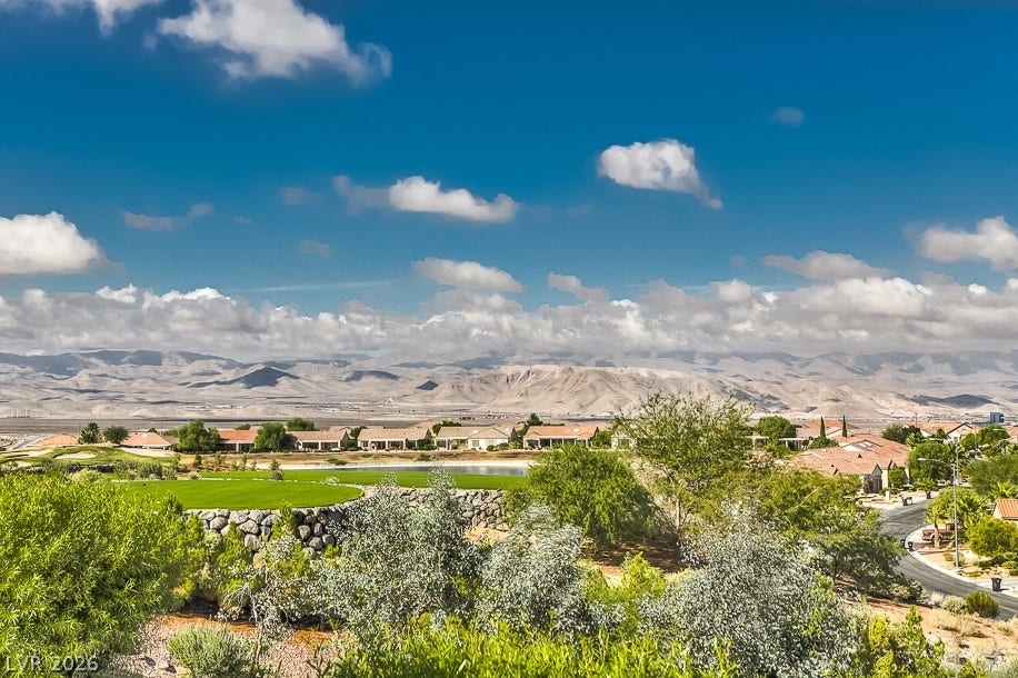 1646 Sebring Hills Drive, Henderson, NV 89052 Dramatic mountain ranges rise beyond manicured neighborhood fairways under a wide blue sky.