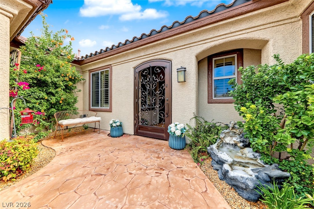 1646 Sebring Hills Drive, Henderson, NV 89052 An inviting gated courtyard entrance welcomes visitors with textured stucco walls and classic tile roofing.