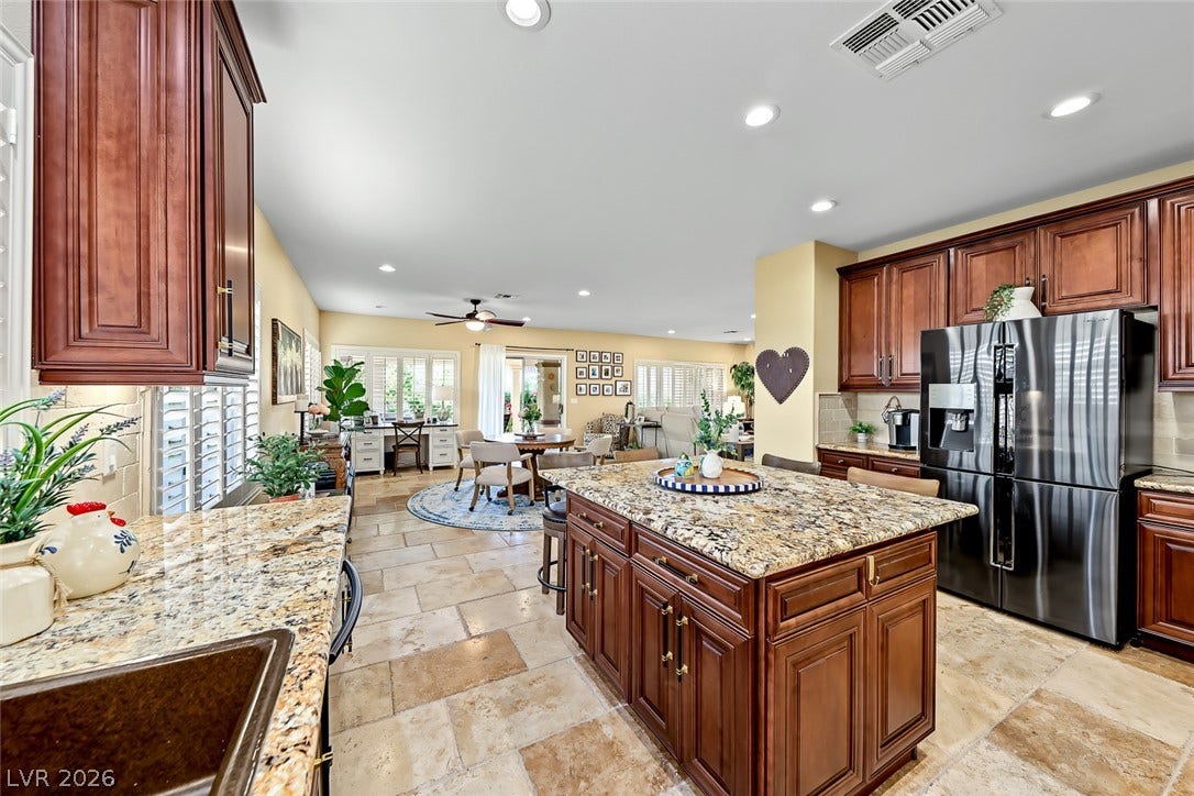 1646 Sebring Hills Drive, Henderson, NV 89052 Rich wood cabinetry and stone countertops anchor this central kitchen overlooking the main living areas.