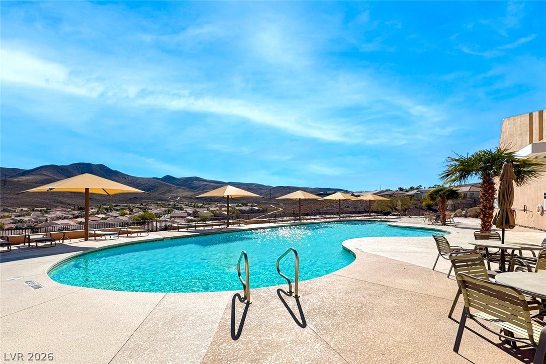 1646 Sebring Hills Drive, Henderson, NV 89052 A curved pool patio overlooks sweeping mountain vistas under a bright blue sky.