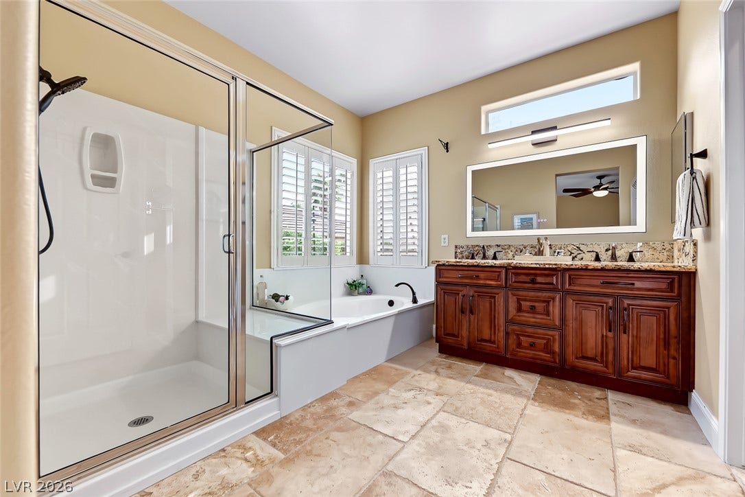 1646 Sebring Hills Drive, Henderson, NV 89052 Natural stone flooring and warm wood cabinetry define this beautifully appointed main bath.