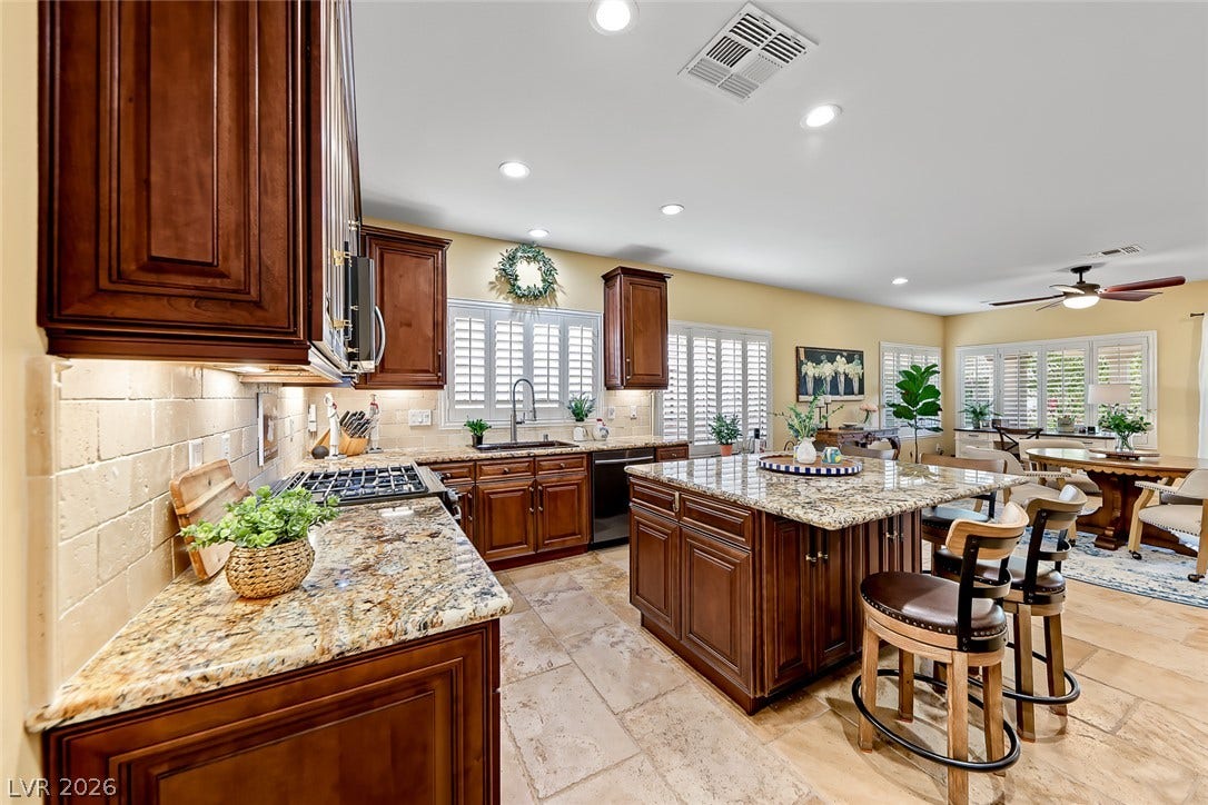 1646 Sebring Hills Drive, Henderson, NV 89052 Rich wood cabinetry and expansive granite countertops anchor this beautifully detailed gourmet workspace.