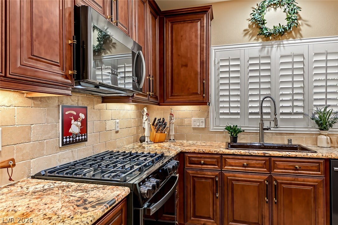 1646 Sebring Hills Drive, Henderson, NV 89052 Rich wood cabinetry surrounds a stone countertop and a gas range.