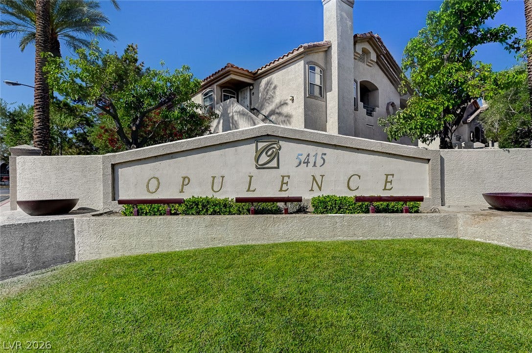 5415 W Harmon Avenue, #1029, Las Vegas, NV 89103 Manicured green lawn surrounds a classic stucco entry sign set against desert-inspired multi-level architecture.