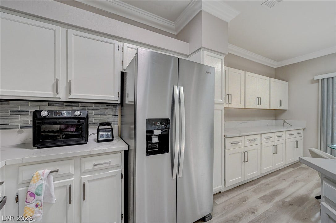 5415 W Harmon Avenue, #1029, Las Vegas, NV 89103 Crisp cabinetry and modern stone counters anchor this bright culinary space with crown molding.