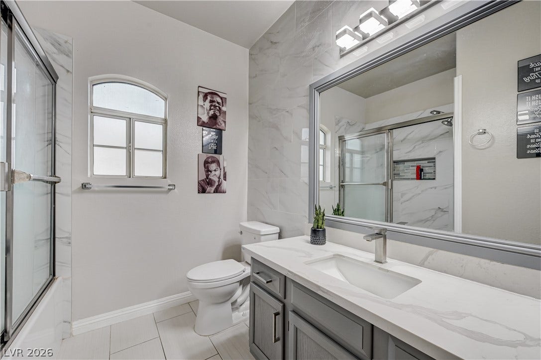 5415 W Harmon Avenue, #1029, Las Vegas, NV 89103 An arched window and tiled accents elevate this modern bathroom layout.