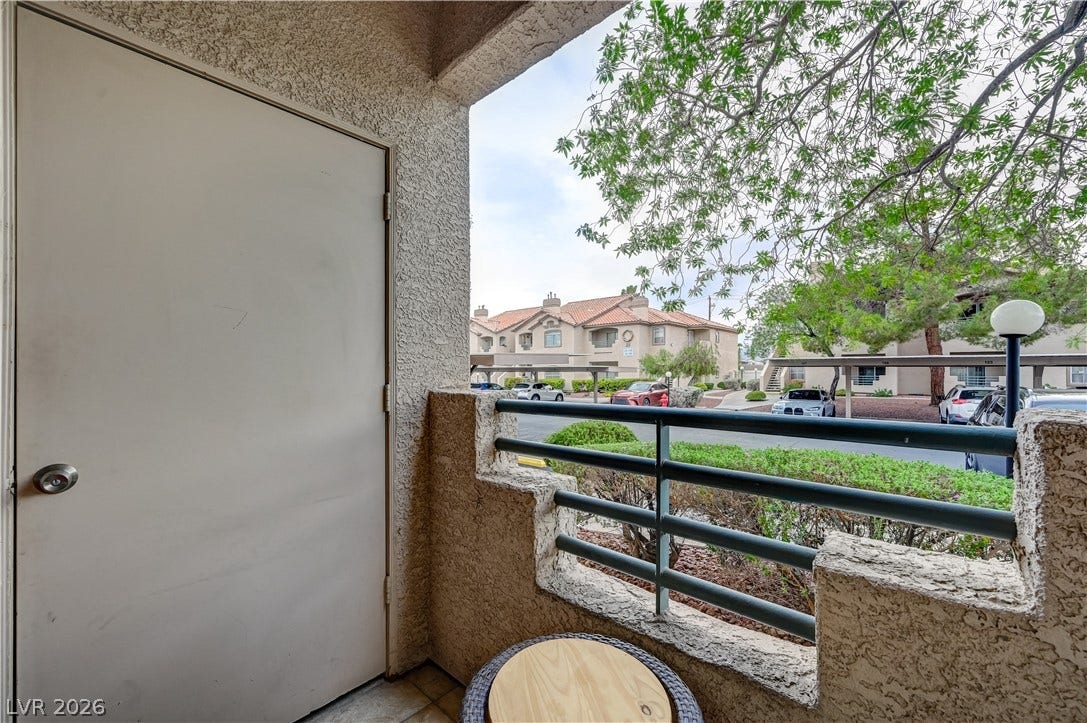 5415 W Harmon Avenue, #1029, Las Vegas, NV 89103 Private outdoor balcony features stucco details and overlooks the surrounding neighborhood landscaping.