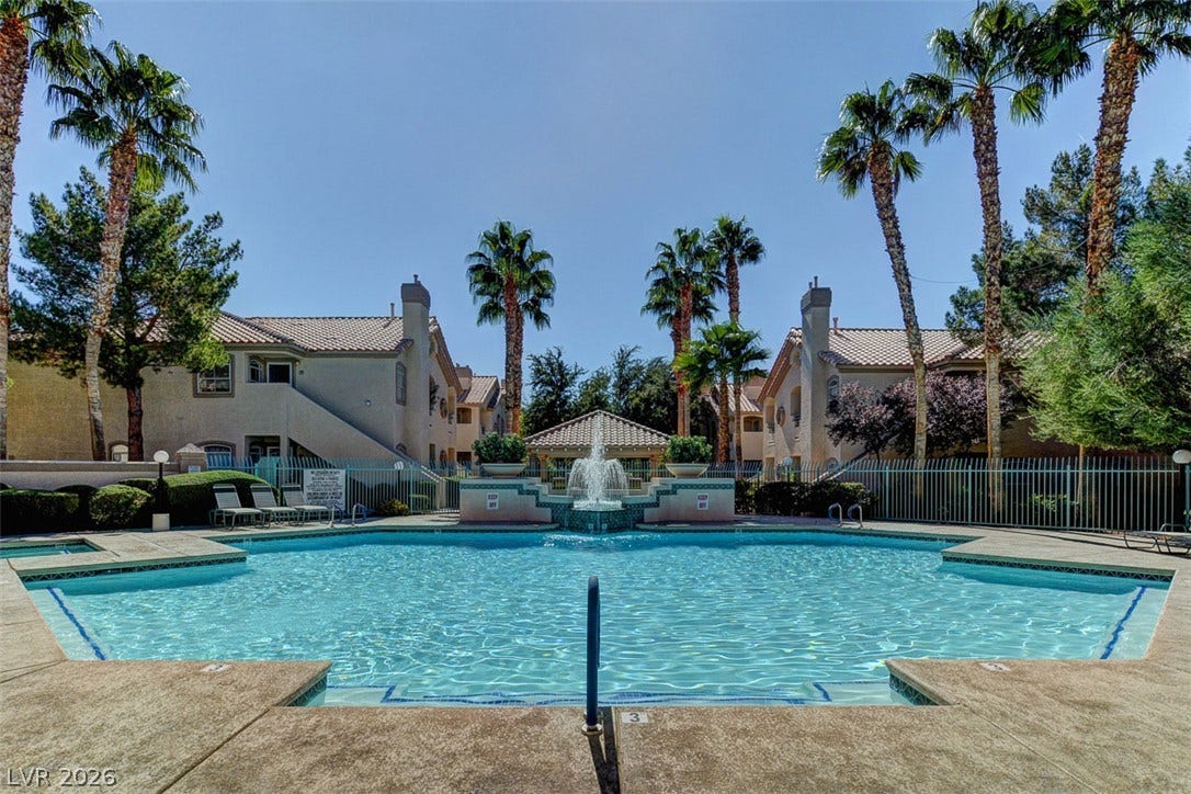5415 W Harmon Avenue, #1029, Las Vegas, NV 89103 A sparkling swimming pool is framed by towering palm trees and classic stucco architecture.