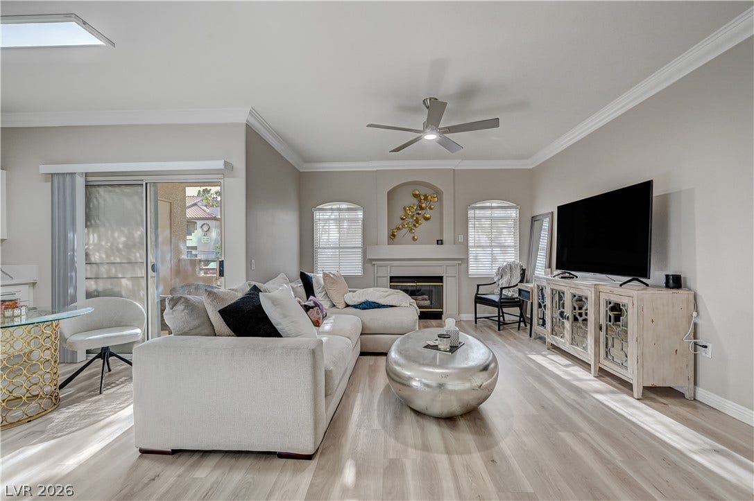 5415 W Harmon Avenue, #1029, Las Vegas, NV 89103 An inviting fireplace and sliding glass doors highlight this elegant living area with wood floors.