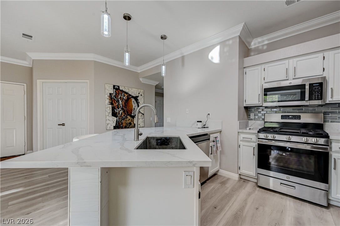 5415 W Harmon Avenue, #1029, Las Vegas, NV 89103 Gleaming stone countertops and modern cabinetry elevate this open kitchen layout.