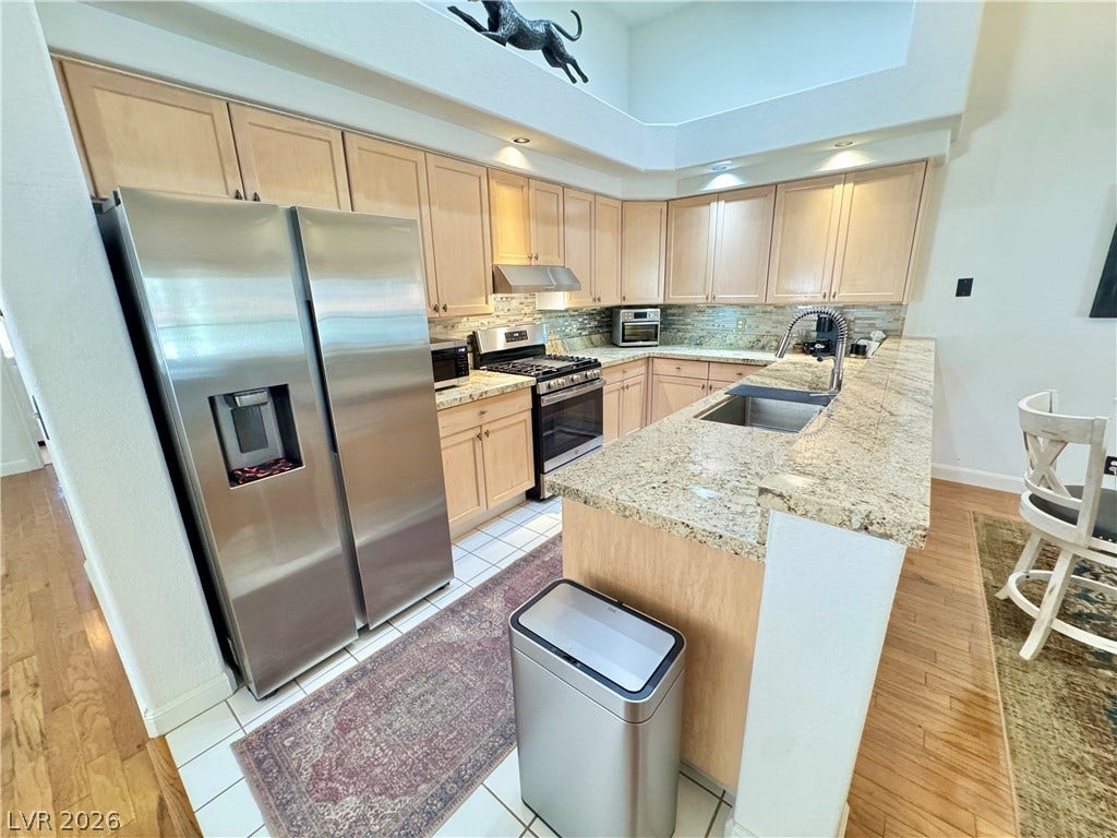 7652 Rolling View Drive, #202, Las Vegas, NV 89149 Gleaming granite countertops pair beautifully with light wood cabinetry in this airy kitchen.