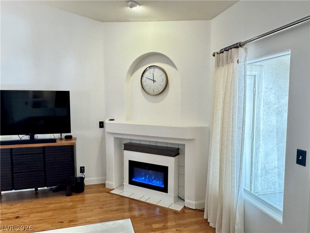7652 Rolling View Drive, #202, Las Vegas, NV 89149 Warm hardwood flooring and a classic fireplace create a welcoming interior space.