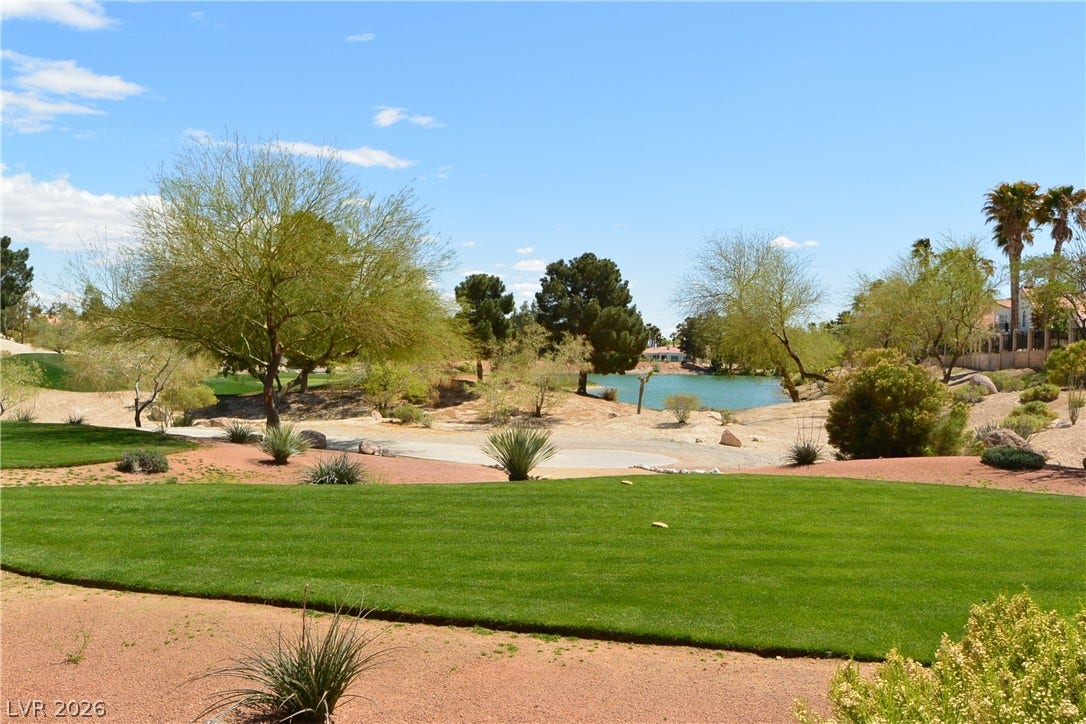 7652 Rolling View Drive, #202, Las Vegas, NV 89149 Lush manicured turf borders desert landscaping with tranquil lake and golf course views beyond.