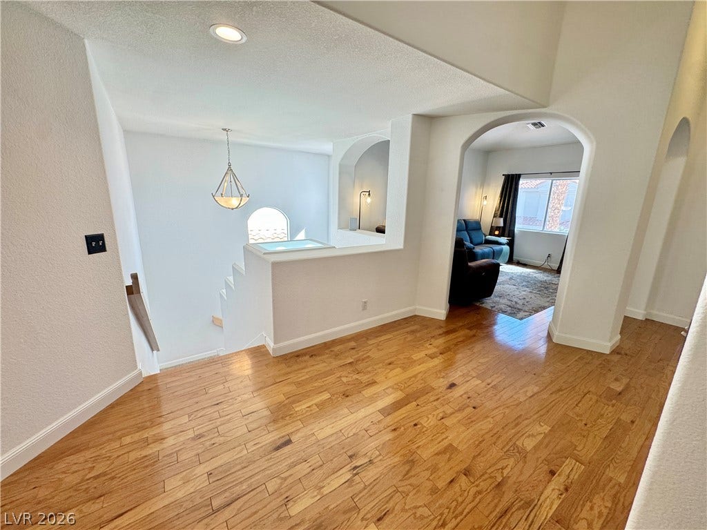 7652 Rolling View Drive, #202, Las Vegas, NV 89149 Rich hardwood flooring anchors this open second-story landing with arched transitions and recessed lighting.