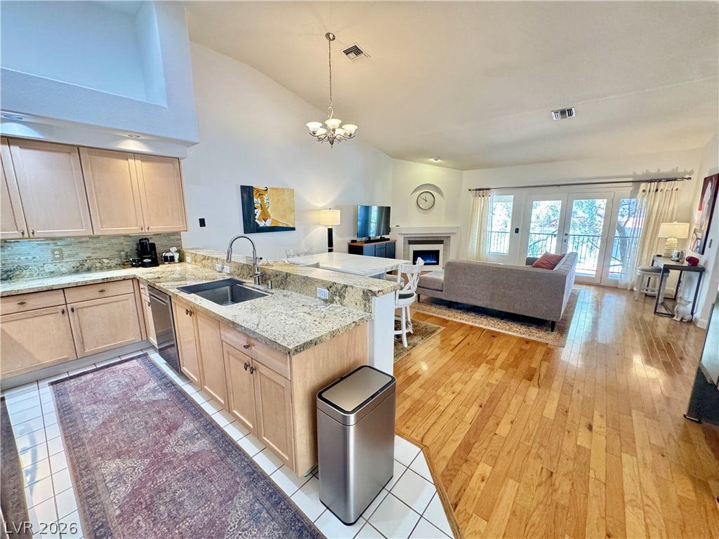7652 Rolling View Drive, #202, Las Vegas, NV 89149 An open floorplan seamlessly connects the kitchen to a light-filled living area with hardwood floors.