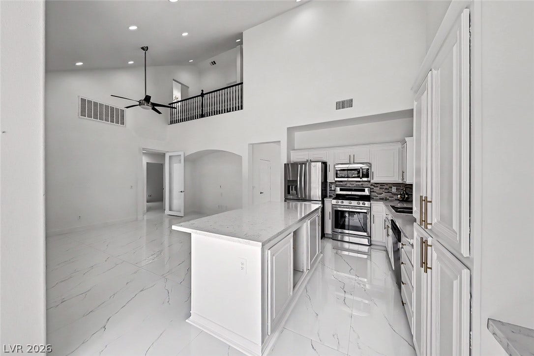 792 Valley Rise Drive, Henderson, NV 89052 An open floorplan connects the modern kitchen and soaring living space with polished stone flooring.
