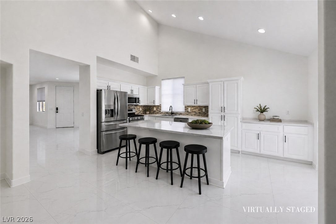 792 Valley Rise Drive, Henderson, NV 89052 High vaulted ceilings and sleek stone tile floors define this airy, modern kitchen workspace.