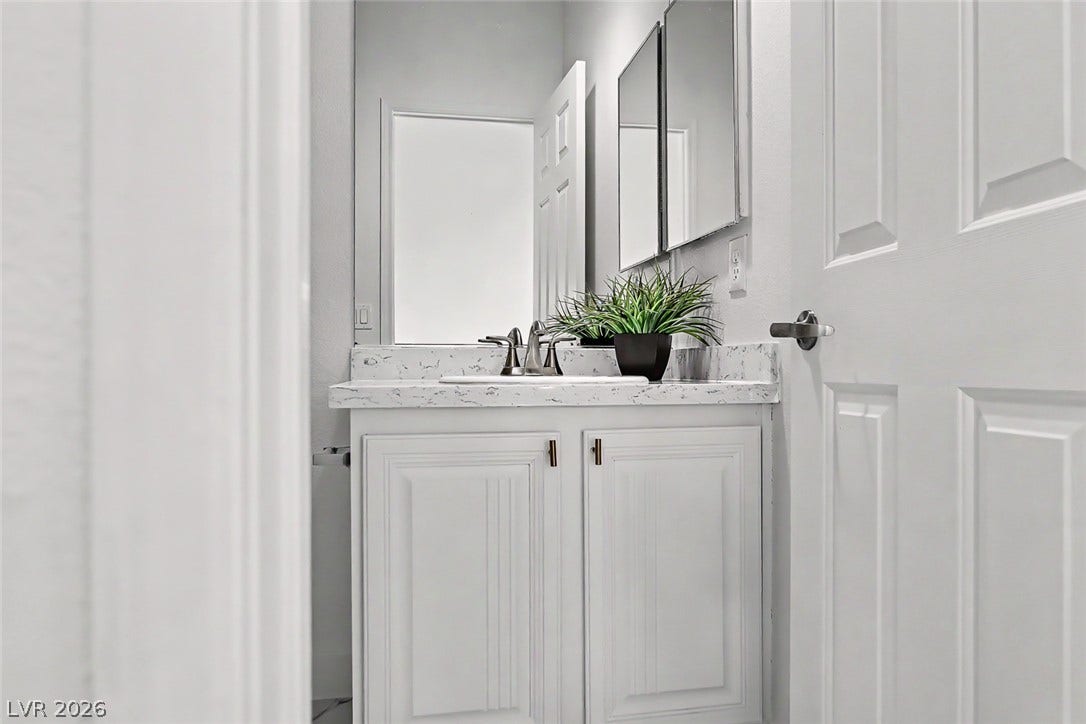 792 Valley Rise Drive, Henderson, NV 89052 A classic white vanity is topped with elegant stone counters in this compact bathroom.