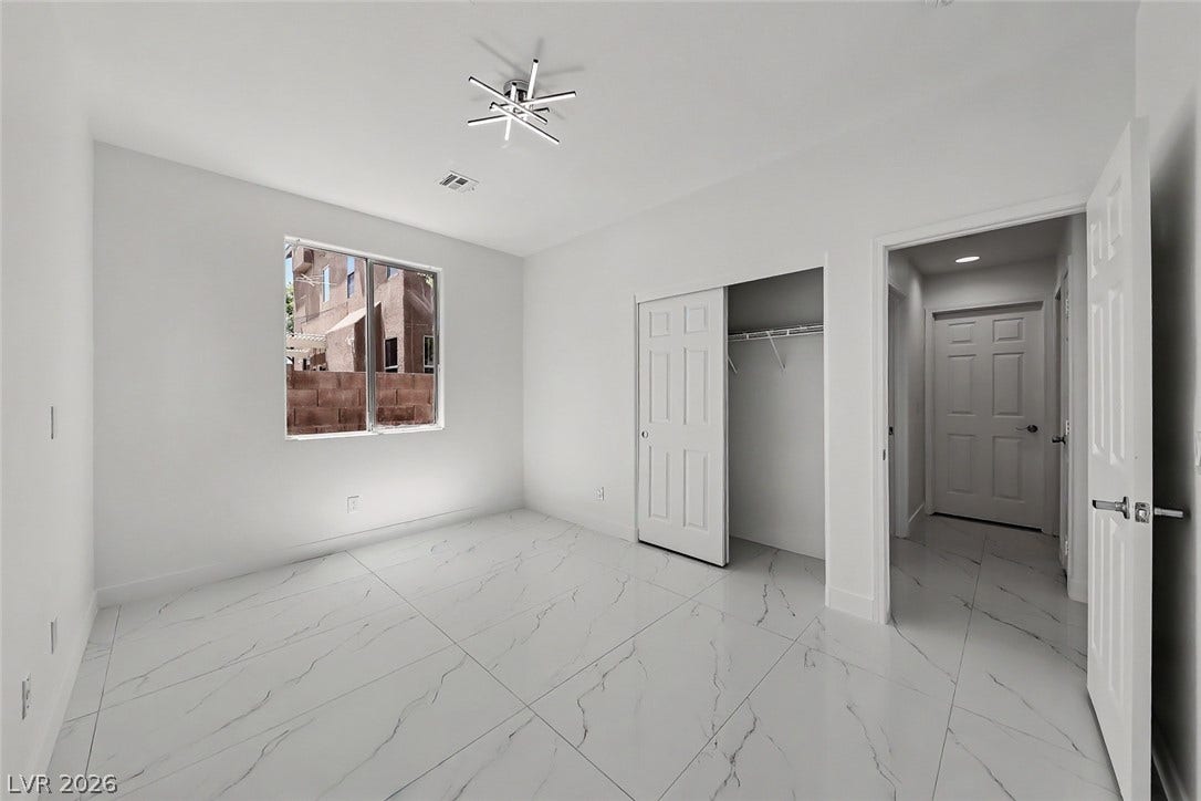 792 Valley Rise Drive, Henderson, NV 89052 Polished tile floors and crisp white finishes define this light-filled guest bedroom space.