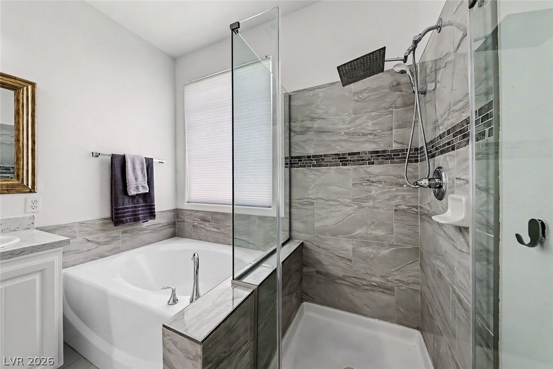 792 Valley Rise Drive, Henderson, NV 89052 A glass-enclosed shower stands next to a deep soaking tub in this bathroom.